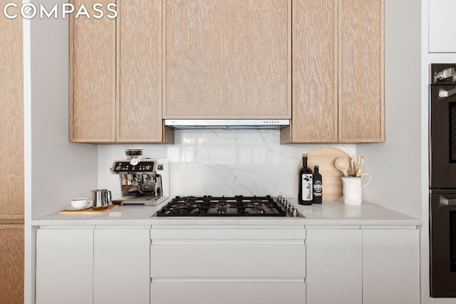 kitchen with double oven, black gas cooktop, decorative backsplash, and light brown cabinets