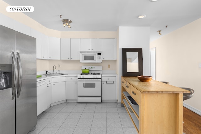 kitchen with sink, white cabinets, and white appliances