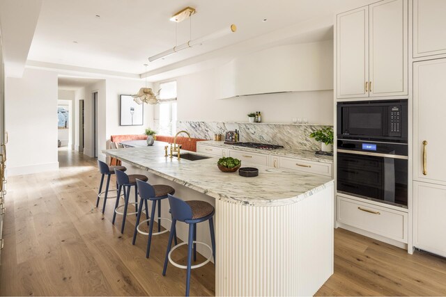 living room featuring beamed ceiling and light hardwood / wood-style flooring