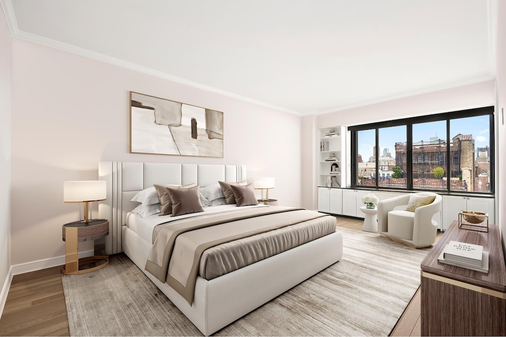 bedroom featuring ornamental molding, baseboards, a city view, and light wood finished floors