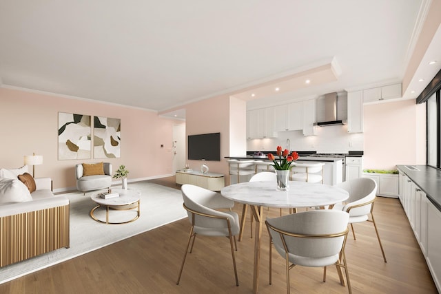 dining space with light wood-type flooring, crown molding, and recessed lighting