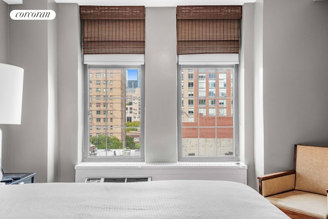 bedroom with multiple windows and a city view