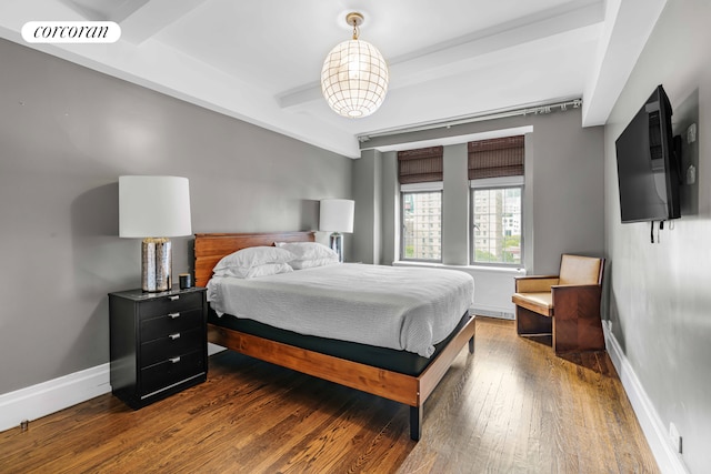 bedroom with wood-type flooring, beam ceiling, visible vents, and baseboards