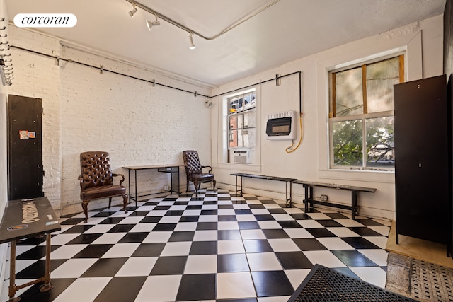 sitting room featuring cooling unit, rail lighting, and heating unit