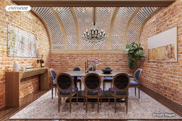 dining room featuring a notable chandelier and brick wall