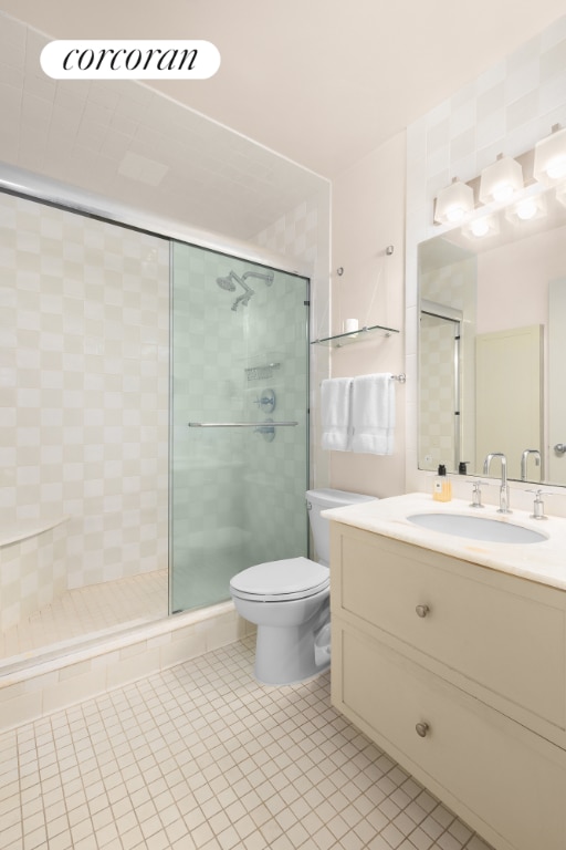 bathroom featuring toilet, a stall shower, tile patterned flooring, and vanity