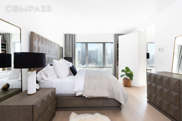 bedroom featuring connected bathroom and light wood-style floors