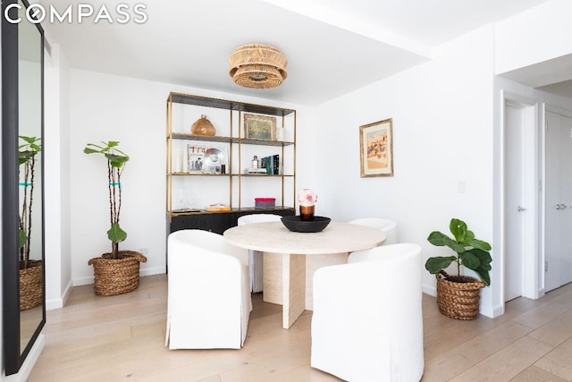 dining area featuring light wood-style flooring and baseboards