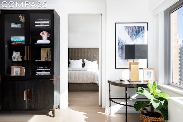 bedroom with multiple windows and wood finished floors