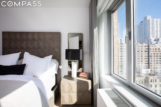 bedroom featuring a city view and radiator heating unit