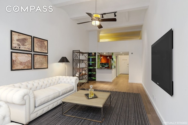living room with wood finished floors, beamed ceiling, high vaulted ceiling, ceiling fan, and baseboards