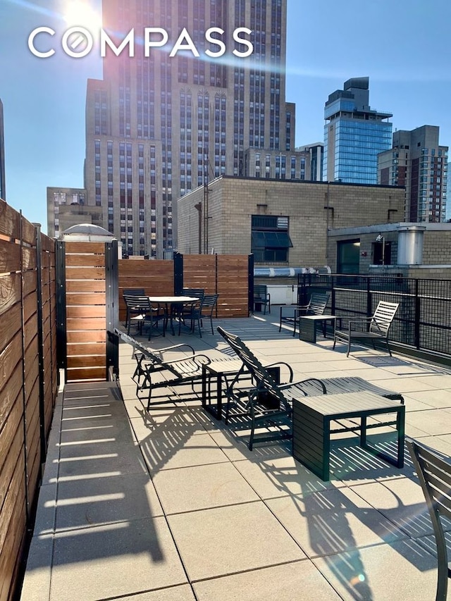 view of patio featuring a city view and fence