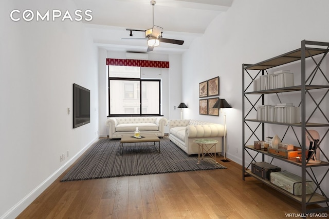 living area featuring baseboards, wood finished floors, and a ceiling fan