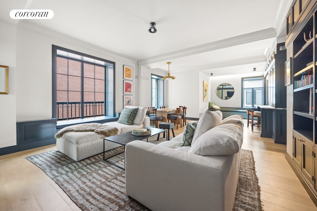 living area featuring visible vents, light wood-style flooring, and ornamental molding