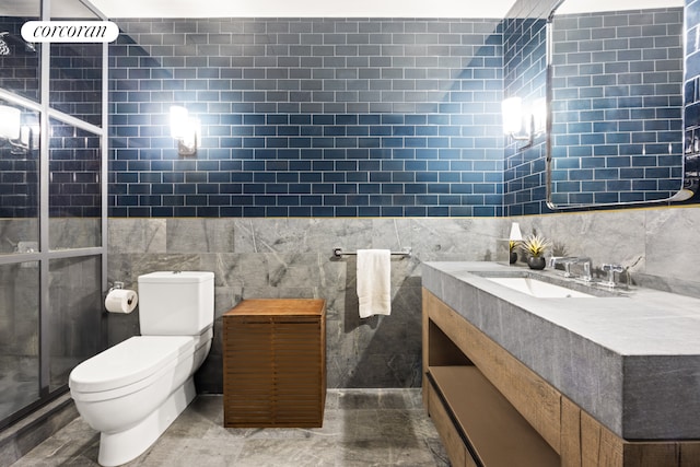 bathroom with toilet, tile walls, a stall shower, and vanity