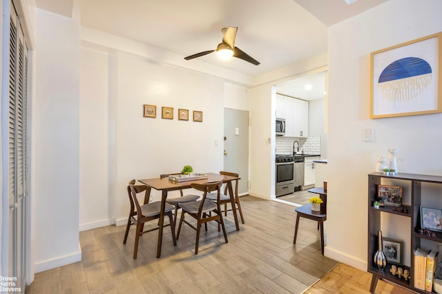 dining room with baseboards, light wood-style floors, and ceiling fan