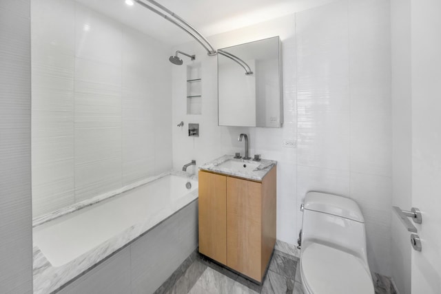 bathroom with toilet, vanity,  shower combination, and tile walls