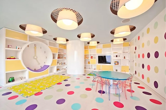 playroom featuring wallpapered walls and built in shelves