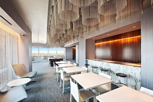 carpeted dining room with a towering ceiling