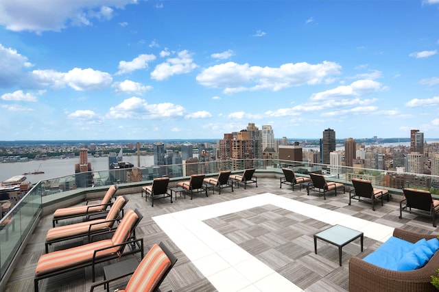 view of patio / terrace with a water view, a view of city, and an outdoor hangout area