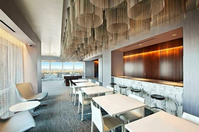 carpeted dining area featuring a towering ceiling