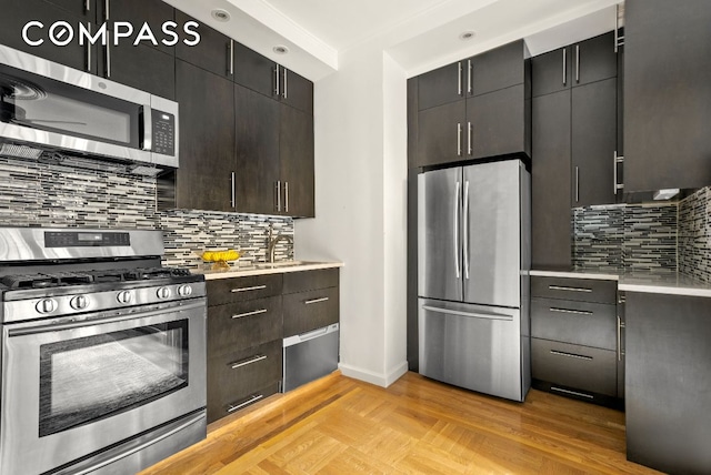 kitchen with appliances with stainless steel finishes, sink, backsplash, dark brown cabinetry, and light wood-type flooring