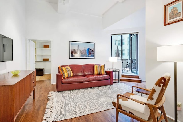 living area with light wood-type flooring and high vaulted ceiling