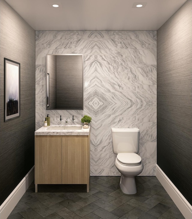 bathroom featuring recessed lighting, toilet, vanity, and baseboards