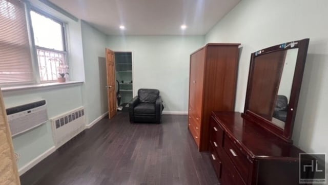 sitting room with dark wood finished floors, recessed lighting, radiator, and baseboards