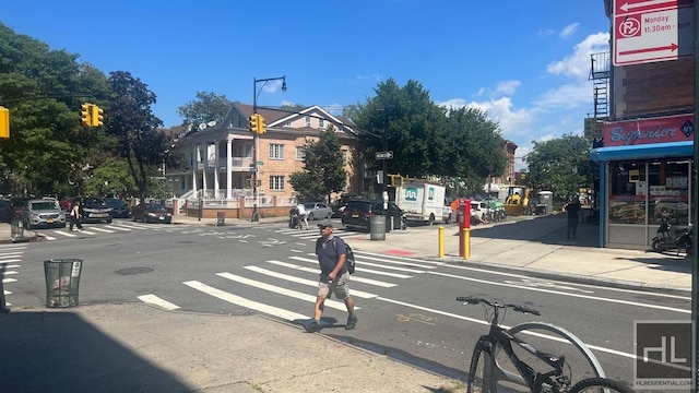 view of street featuring sidewalks, curbs, traffic signs, and traffic lights