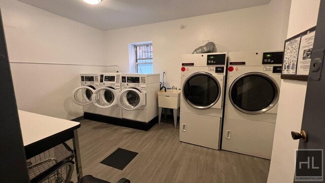 common laundry area featuring washer and clothes dryer and wood finished floors