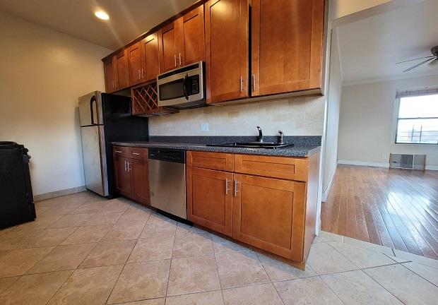 kitchen featuring light tile patterned floors, ceiling fan, stainless steel appliances, decorative backsplash, and sink