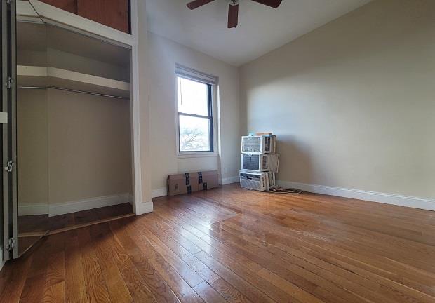 unfurnished bedroom with ceiling fan, lofted ceiling, a closet, and hardwood / wood-style flooring