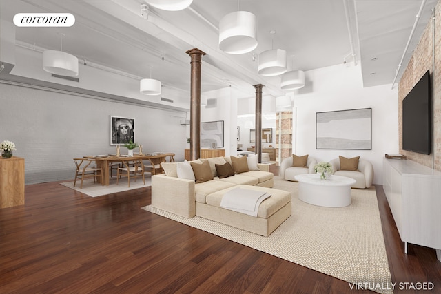 living room with visible vents, wood finished floors, and decorative columns