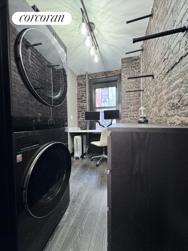 home office with stacked washer / dryer and wood finished floors