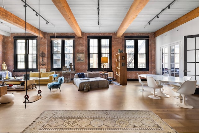 interior space featuring rail lighting and brick wall