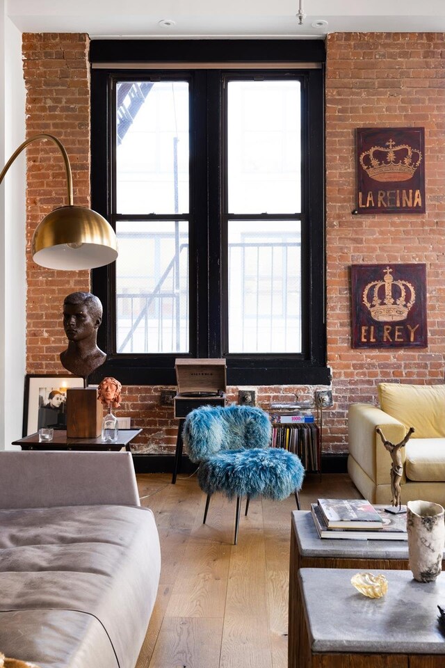 interior space with brick wall and hardwood / wood-style flooring