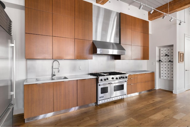 31 Washington St Unit 11, New York City, NY 11201 - kitchen with high end appliances, wall chimney exhaust hood, track lighting, dark wood-type flooring, and brown cabinetry