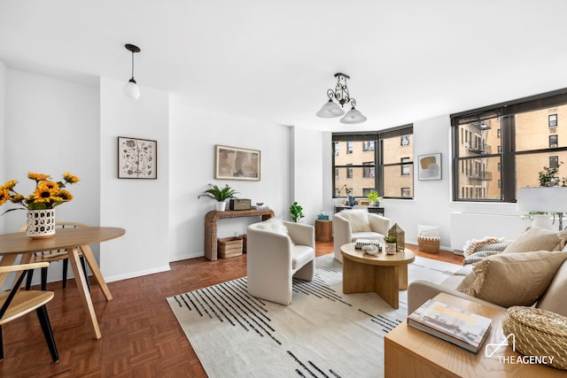 living room with baseboards and an inviting chandelier