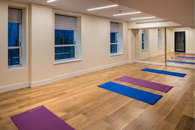 workout area featuring wood finished floors and baseboards