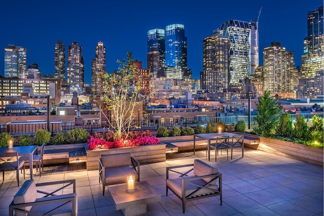 surrounding community featuring a view of city lights and a patio area