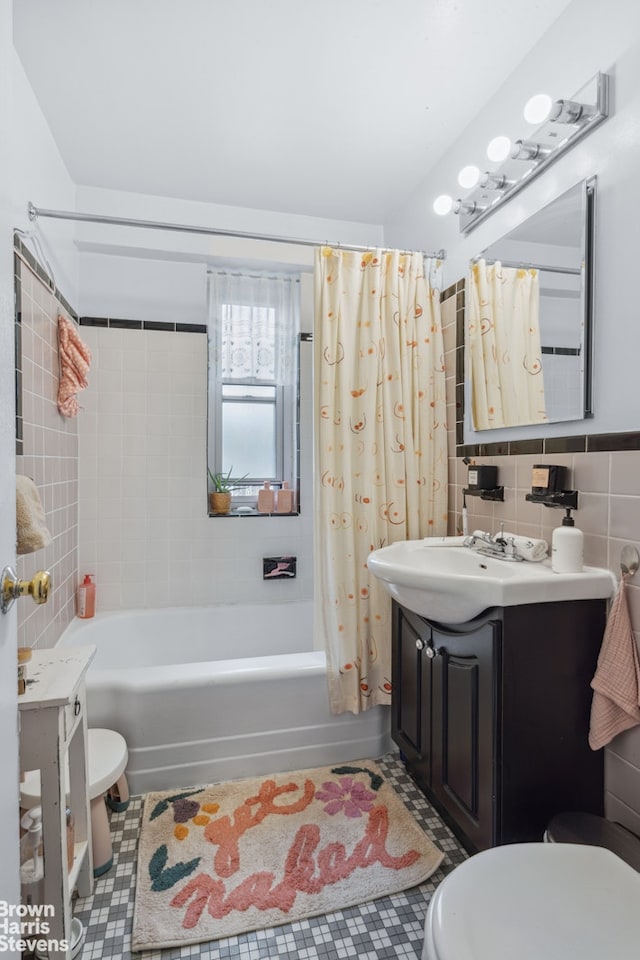 bathroom featuring shower / bath combo, toilet, tile patterned flooring, vanity, and tile walls