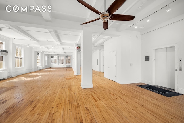 118 E 25th St Unit 8, New York City, NY 10010 - unfurnished living room featuring elevator, a ceiling fan, beam ceiling, track lighting, and light wood-style floors