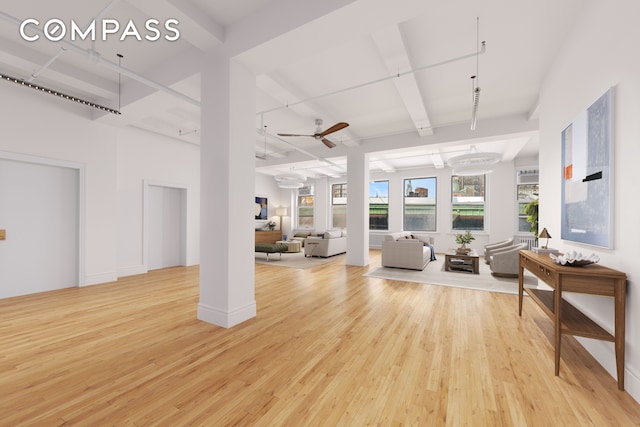 interior space featuring light wood finished floors, beam ceiling, and ceiling fan