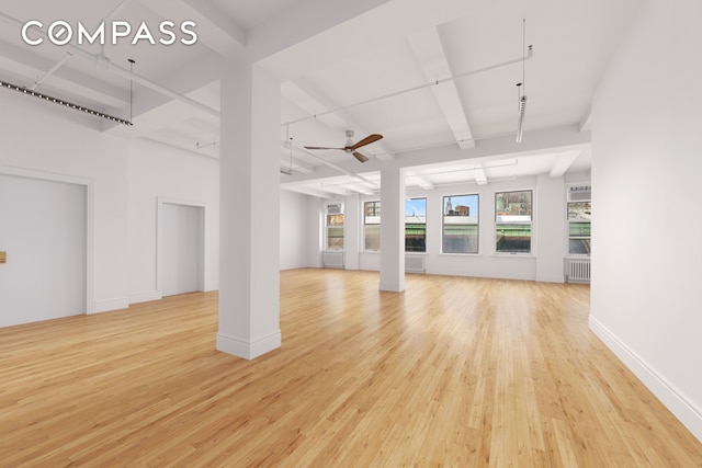 118 E 25th St Unit 8, New York City, NY 10010 - unfurnished living room with light wood-style flooring, ceiling fan, decorative columns, baseboards, and radiator