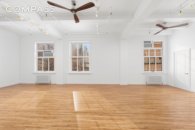 118 E 25th St Unit 8, New York City, NY 10010 - unfurnished living room with a ceiling fan, radiator, light wood-type flooring, rail lighting, and beamed ceiling