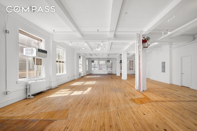 118 E 25th St Unit 8, New York City, NY 10010 - unfurnished living room featuring radiator, electric panel, hardwood / wood-style floors, and ceiling fan