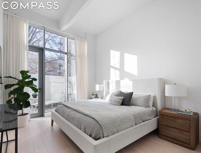 bedroom featuring hardwood / wood-style flooring, access to exterior, and beam ceiling