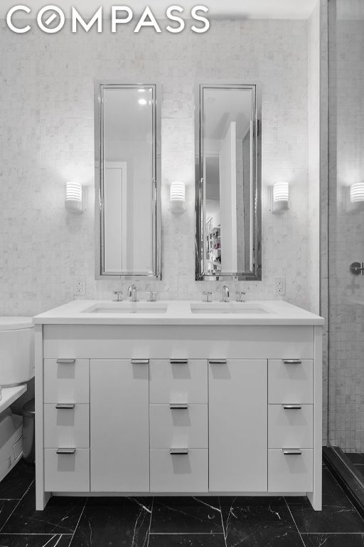 bathroom featuring walk in shower, vanity, and toilet