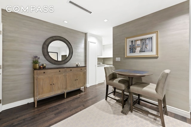 dining room featuring dark wood-style flooring, visible vents, and baseboards